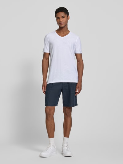 Męski model nosi T-Shirt mit V-Ausschnitt und Rollsaum od MCNEAL z bawełny, krój regular fit, biały, gładka tekstura, długość tyłu 81 cm, Ganzkörperansicht von vorne.