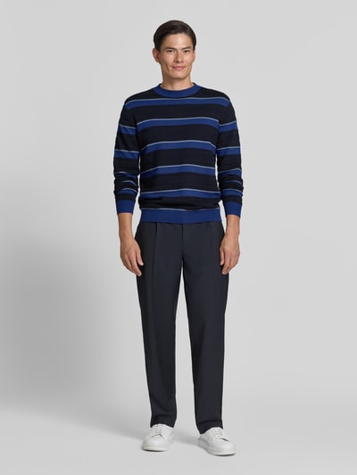 Männermodel trägt Strickpullover mit Struktur-Muster von Armani Exchange in Blau mit Rundhalsausschnitt, lockerer Schnitt, Ganzkörperansicht von vorne.