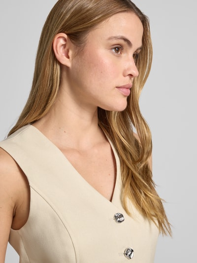 Kobiece model prezentuje Weste aus Viskose-Mix mit Knopfleiste Modell 'Esteriane' od MSCH Copenhagen, beżowy kolor, krój slim fit, tkanina z fakturą, V-dekolt, szczegóły: szerokość w rozmiarze S 41 cm, długość pleców 61 cm, szerokość ramion 35 cm, zbliżenie na górną część ciała z przodu