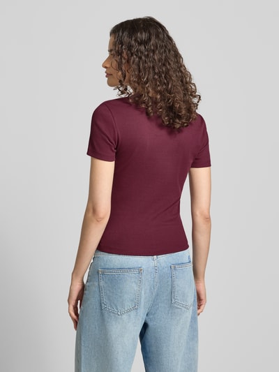 Frauenmodel trägt Regular Fit T-Shirt aus Baumwoll-Mix Modell 'VAL' von ONLY in Bordeaux, kombiniert mit Jeans, Damen T-Shirt, Ganzkörperansicht Rückansicht.