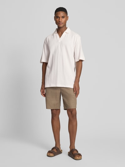 Männermodel trägt Relaxed Fit Poloshirt mit Strukturmuster Modell 'DALIBO' von HUGO, Optik: Unifarben, feines Strukturmuster, Label-Stitching-Applikation, Polokragen, V-Ausschnitt, Kurzarm, Materialverarbeitung: Jersey, Material: reine Baumwolle, Ganzkörperansicht von vorne.