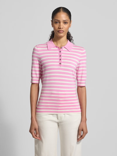 Frauenmodel trägt Poloshirt aus Viskose-Mix von Christian Berg Woman mit rosa-weißen Streifen, gerader Schnitt, Polokragen, 1/2-Arm, Ganzkörperansicht von vorne.