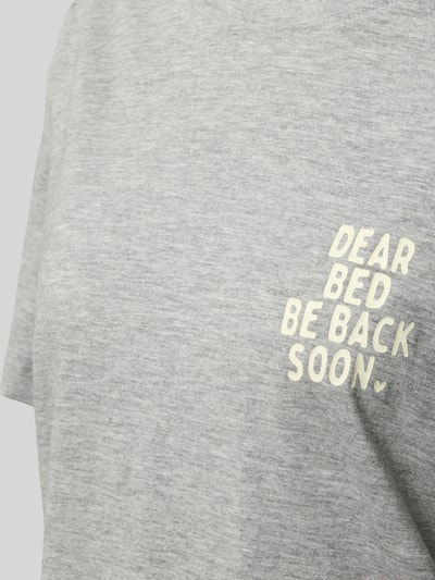 Frauenmodel trägt graues Pyjama-Oberteil mit Statement-Print von Jake*s Casual aus Baumwoll-Viskose-Mix, Regular-Fit, Rundhalsausschnitt, Nahaufnahme Oberkörper.