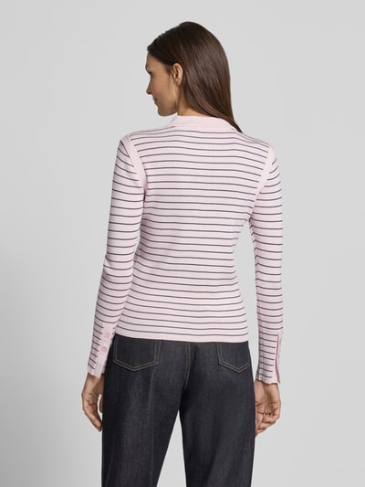Männermodel trägt Langarmshirt mit Polokragen Modell 'VERAN' von Copenhagen Muse, różowy z ciemnymi paskami, krój slim fit, viskose z domieszką stretchu, guziki przy mankietach, widoczna faktura prążków, widok całej sylwetki z tyłu.