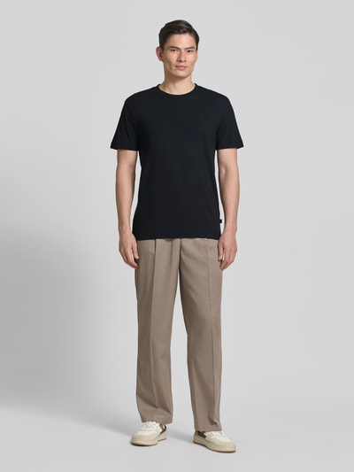 Männermodel trägt T-Shirt mit Rundhalsausschnitt Modell 'Carlonito' von JOOP! Collection in Schwarz, Baumwoll-Mix, Ganzkörperansicht von vorne.