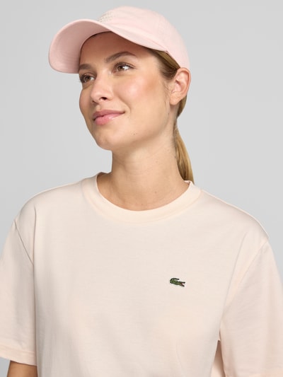Frauenmodel trägt Relaxed Fit T-Shirt aus reiner Baumwolle von Lacoste in hellem Beige, glatte Textur, Nahaufnahme Oberkörper, Damen T-Shirt von Lacoste.