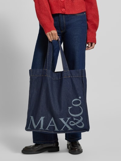 Frauenmodel trägt Loose Fit Jeans aus reiner Baumwolle Modell 'CALESSE' von MAX&Co., dunkelblauer Denim, 5-Pocket-Design, Twillstruktur, Nahaufnahme Unterkörper.