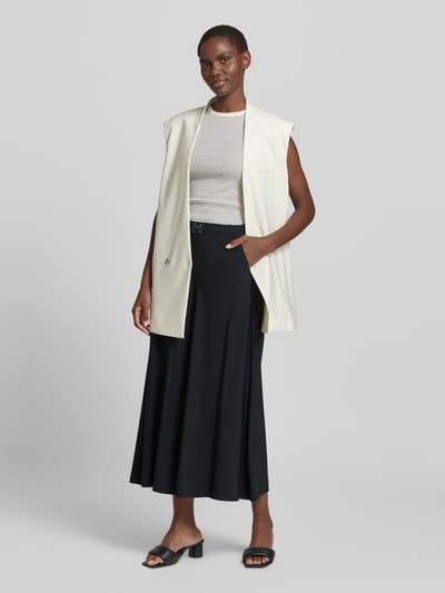 Frauenmodel trägt Hose in verkürzter Passform mit Gürtel Modell 'Pia' von MAC, aus Material-Mix mit Stretch-Anteil, weites Bein, elastischer Bund, innenbeinlänge 65 cm, Bundweite 39 cm, elegant in Schwarz, Ganzkörperansicht von vorne.