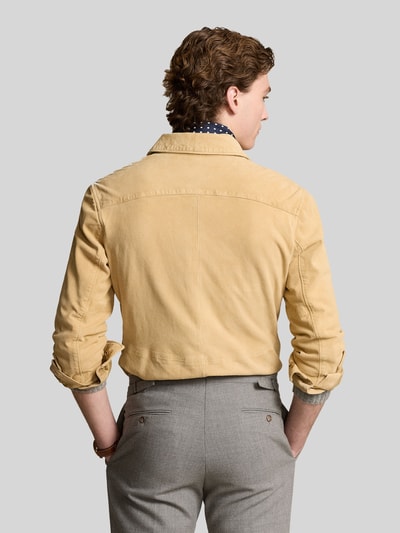Mężczyznę model prezentuje Suede-Hemdjacke aus Ziegenwildleder od Polo Ralph Lauren w kolorze beżowym, prosty krój, prosty kołnierz, długie rękawy, kieszenie z patką na piersi, materiał z koziej skóry z widoczną fakturą, Szerokość pleców w rozmiarze M: 45 cm, długość pleców: 63 cm, szerokość klatki piersiowej: 41 cm, długość rękawa: 66 cm; widok całej sylwetki z tyłu