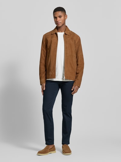 Männermodel trägt Hose mit Eingrifftaschen Modell 'Chuck' von Brax, Slim Fit, Baumwoll-Mix mit Lyocell, dunkelblau, Ganzkörperansicht von vorne.