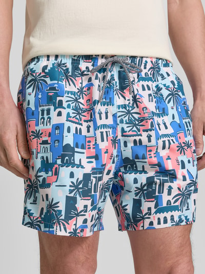 Männermodel trägt Badehose im Allover-Look Modell 'Vacay Villas' von BOARDIES, bunte Muster, elastischer Bund, Nahaufnahme Oberkörper.