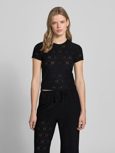 Frauenmodel trägt schwarzes Relaxed Fit T-Shirt mit Ausbrenner-Effekt Modell 'SMILLA' von Only, rundhals, kurzarm, Ganzkörperansicht von vorne.