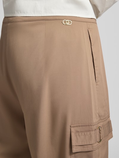 Frauenmodel trägt Hose mit elastischem Bund und Cargotaschen von LIU JO SPORT in Beige, Material-Mix mit Viskose-Anteil, Detailaufnahme.