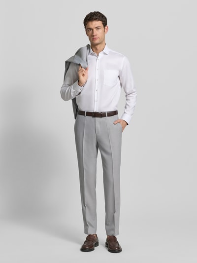 Männermodel trägt Skinny Fit Anzughose mit Woll-Anteil Modell 'HESTEN253X' von HUGO, Optik: Allover-Muster, Ganzkörperansicht von vorne.