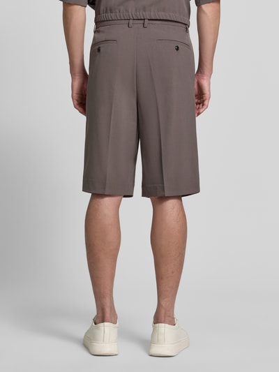 Männermodel trägt Straight Fit Shorts mit Viskose-Anteil von Lindbergh in Braun mit Bundfalten und Gesäßtaschen, Ganzkörperansicht Rückansicht. Elastischer-Material-Mix, Haken-Reißverschluss, Bundweite 44 cm, Innenbeinlänge 30 cm bei Größe M.