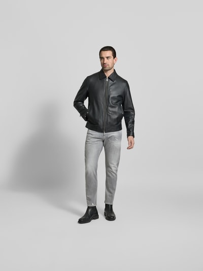 Männermodel trägt Slim Fit Jeans mit Logo-Detail von Dsquared2 aus elastischem Baumwoll-Mix im 5-Pocket-Design, graue Farbe, Ganzkörperansicht von vorne.