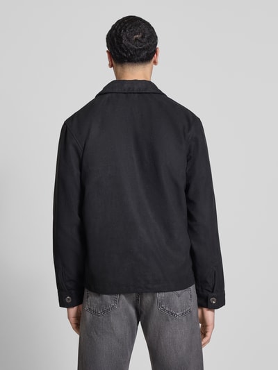 Männermodel trägt Regular Fit Jacke in Lederoptik Modell 'RICK' von Only & Sons, unifarben schwarz, Umlegekragen, Ganzkörperansicht Rückansicht.