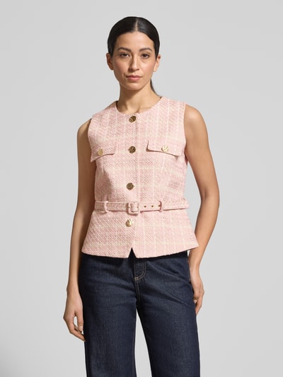 Frauenmodel trägt Weste in Bouclé-Optik mit Gürtel von Christian Berg Woman Selection, Baumwoll-Viskose-Mix, Regular-Fit, Rundhalsausschnitt, Knopfleiste, rosa mit goldfarbenen Knöpfen, vorne aufgesetzte Taschen, strukturierte Textur, Brustweite 44 cm, Schulterbreite 37 cm, Rückenlänge 55 cm, Ganzkörperansicht von vorne.