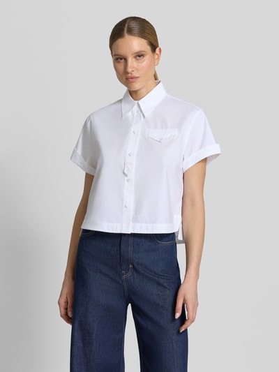 Frauenmodel trägt Boxy Fit Bluse mit Brusttasche von Luisa Cerano aus weißer Baumwolle mit Hemdblusenkragen und Knopfleiste, Ganzkörperansicht von vorne.