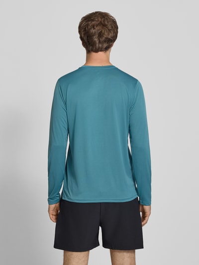 Männermodel trägt Funktionsshirt mit Rundhalsausschnitt und Logo von New Balance in Blau, glatte Textur, Ganzkörperansicht Rückansicht. Regular Fit, Longsleeve, Rückenlänge bei Größe M 72 cm.