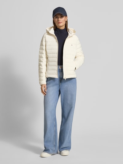 Frauenmodel trägt Slim Fit Kurtka puchowa z odpinanym kapturem od Tommy Hilfiger, jednolity kolor, stójka, zamek błyskawiczny, haftowane logo, długi rękaw z elastycznym wykończeniem, zaokrąglony dół, hydrofobowy materiał, boczne kieszenie na zamek; ganzkörperansicht von vorne.