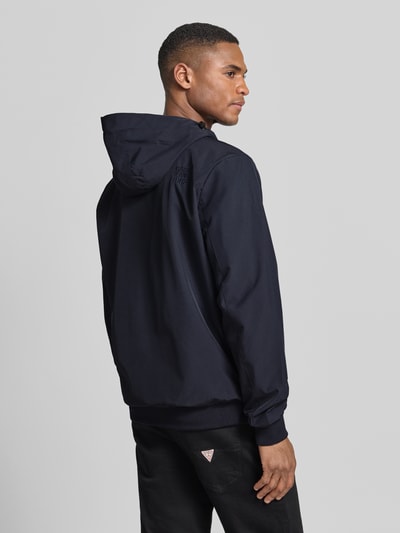 Männermodel trägt Jacke mit Reißverschlusstaschen Modell 'MATTEO' von CARS JEANS in Dunkelblau, Material-Mix mit Stretch-Anteil, Regular-Fit, Kapuze mit Tunnelzug, Rückenlänge bei Größe M 70 cm, Schulterbreite 44 cm, Brustweite 50 cm, Ärmellänge 70 cm, Ganzkörperansicht Rückansicht.