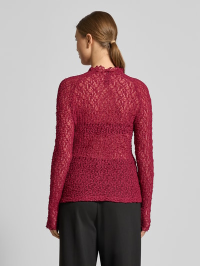 Frauenmodel trägt Slim Fit Longsleeve in semitransparentem Design von Marc Cain, rote Spitze, Rundhalsausschnitt, Ganzkörperansicht Rückansicht.