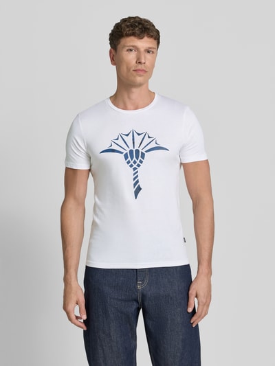 Männermodel trägt T-Shirt mit Rundhalsausschnitt Modell 'Alerio' von JOOP! Collection, weiß mit blauem Logo, Regular Fit, reine Baumwolle, Ganzkörperansicht von vorne.