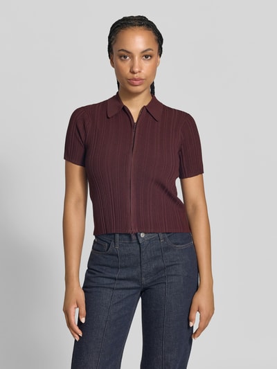 Frauenmodel trägt Shirt mit Zweiwege Reißverschluss von Victoria Beckham in Dunkelrot, Strukturstrick, Slim Fit, Ganzkörperansicht von vorne.