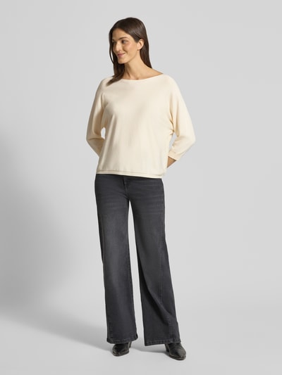 Frauenmodel trägt Strickpullover aus Viskose-Mix mit rückseitiger Schnürung von Comma, Damen, Regular-Fit, U-Boot-Ausschnitt, 3/4-Arm, cremige Farbe, glatte Textur, kombiniert mit dunkler Jeans, Ganzkörperansicht von vorne.