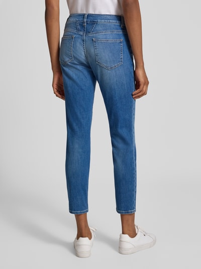 Modelka nosi Slim Fit Jeans aus Baumwoll-Mix Modell 'Baker' od Closed, klasyczny niebieski, 5 kieszeni, zapięcie na guzik i zamek błyskawiczny, skrócony krój, widok całej sylwetki z tyłu.