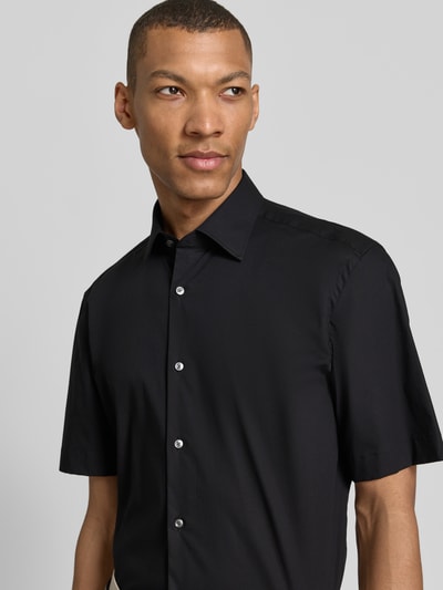 Männermodel trägt Regular Fit Businesshemd aus Baumwoll-Mix Modell 'H-JOE-K-SH-C1-262' von BOSS, Optik: Unifarben, Nahaufnahme Oberkörper.