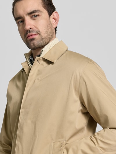 Männermodel trägt Regular Fit Regenjacke mit Baumwoll-Anteil Modell 'ROKIG' von Barbour in Beige, einfarbig, Nahaufnahme Oberkörper.