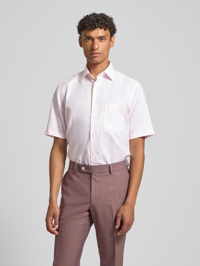 Męski model nosi Regular Fit Business-Hemd mit Kentkragen von OLYMP, bawełna, krój regular fit, jednolity, strukturalny wzór, kieszeń na piersi, długość tyłu w rozmiarze 40: 80 cm, szerokość w rozmiarze 40: 47 cm, długość rękawa w rozmiarze 40: 27 cm, jasnoróżowy, widok całej sylwetki z przodu.