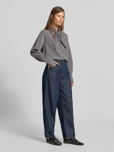 Frauenmodel trägt Regular Fit Hemdbluse mit Viskose-Anteil von MYON in Grau, langer Schnitt, Stehkragen, Knopfleiste, Ganzeansicht von vorne.