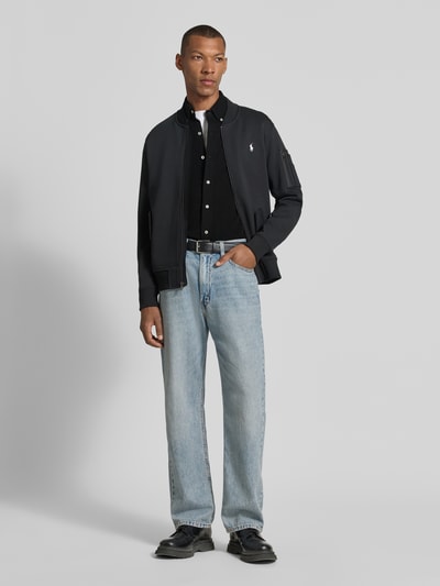 Männermodel trägt Regular Fit Freizeithemd aus reiner Baumwolle von Polo Ralph Lauren in Schwarz, kombiniert mit Jeans, Ganzkörperansicht von vorne.