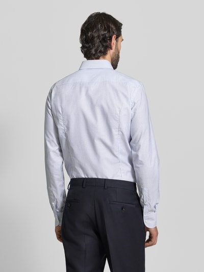 Männermodel trägt Slim Fit Businesshemd aus Lyocell-Baumwoll-Mix Modell 'HANK' von BOSS mit Allover-Muster, Ganzkörperansicht Rückansicht.