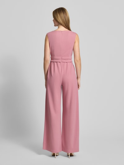 Vrouwenmodel draagt Jumpsuit met Knotendetail van Vera Mont in roze materiaalmix met stretch, regular fit, ruglengte maat 36, totale lengte 150 cm. Ganzkörperansicht Rückansicht.