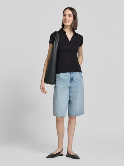 Frauenmodel trägt Damen T-Shirt mit Polokragen Modell 'Kleoh Polo' von Someday, Baumwoll-Elasthan-Mix, Slim-Fit, Ripp-Optik, schwarz; V-Ausschnitt, kombiniert mit hellblauer Bermuda, Rückenlänge bei Größe 36: 60 cm, Ganzkörperansicht von vorne.