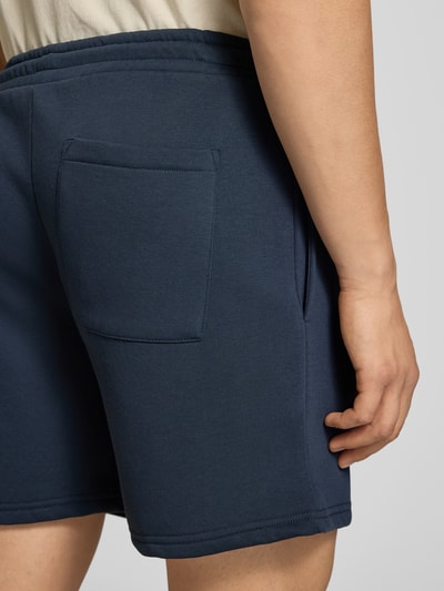 Männermodel trägt Shorts mit Kordelzug und Eingrifftaschen von REVIEW aus Baumwoll-Mix, Gerader-Schnitt, Dunkelblau, Detailaufnahme Rückansicht.
