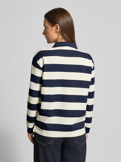 Frauenmodel trägt Sweatshirt mit Polokragen und Knopfleiste von Christian Berg Woman, Material-Mix mit Modal-Anteil, Regular-Fit, Querstreifen in Dunkelblau und Creme, glatte Struktur, Ganzkörperansicht Rückansicht.