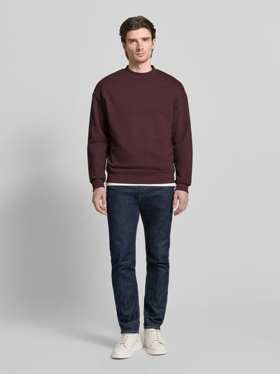 Männermodel trägt Regular Fit Sweatshirt aus reiner Baumwolle Modell 'DAPOCREW' von HUGO, Optik: Unifarben, Label-Print, Ganzkörperansicht von vorne.