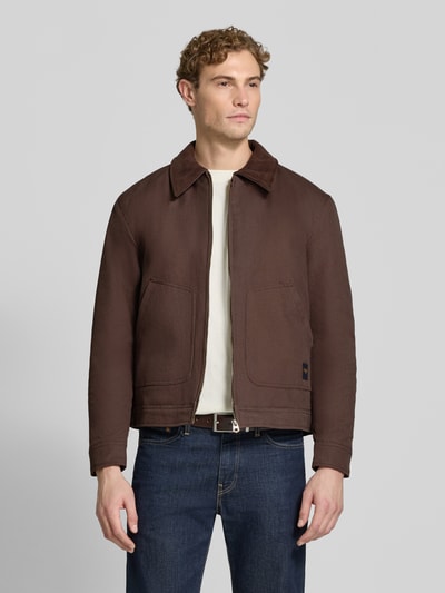 Männermodel trägt Regular Fit Jacke aus reiner Baumwolle von MCNEAL in Braun mit Umlegekragen, aufgesetzten Taschen, Ganzkörperansicht von vorne. Rückenlänge 67 cm, Schulterbreite 53 cm, Brustweite 60 cm, Ärmellänge 66 cm.