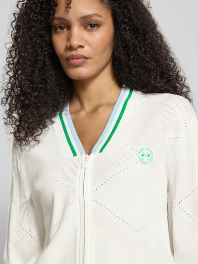 Frauenmodel trägt Strickjacke aus Viskose-Mix mit Zweiwege-Reißverschluss von Marc Cain, Regular-Fit, V-Ausschnitt, Nahaufnahme Oberkörper.