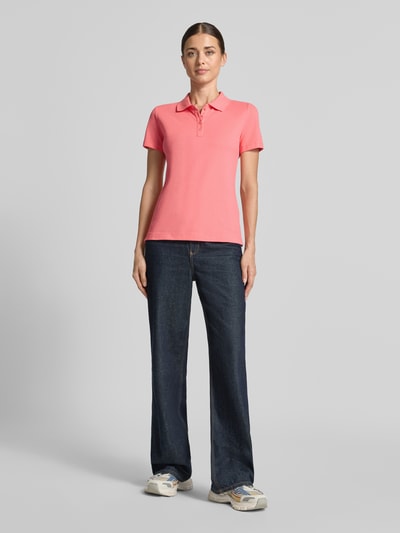 Frauenmodel trägt Regular Fit Poloshirt aus reiner Baumwolle von Tom Tailor in Rosa, kombiniert mit Jeans, Ganzkörperansicht von vorne, Damen Poloshirt von Tom Tailor