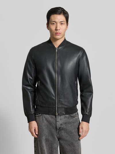 Männermodel trägt Bomberjacke in Leder-Optik mit Zweiwege-Reißverschluss von MARKUP, Material-Mix mit Viskose-Anteil, Regular-Fit, Stehkragen, schwarze Grundfarbe, matte glatte Textur, Ganzkörperansicht von vorne.