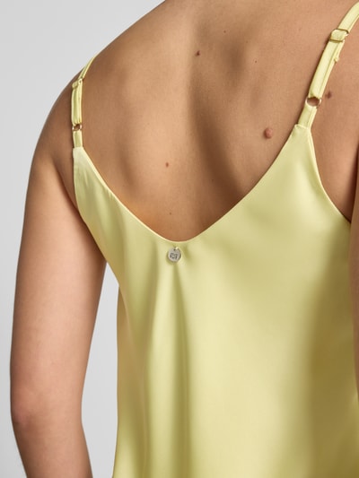 Frauenmodel trägt Top mit V-Ausschnitt und Spaghettiträgern von Rinascimento, gelber Satin, Loose Fit, Detailaufnahme Rückenansicht.