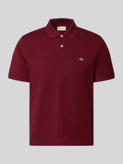 Produktfoto, Regular Fit Poloshirt aus reiner Baumwolle von GANT in Dunkelrot mit klassischem Kragen und glatter Textur vor grauem Hintergrund.
