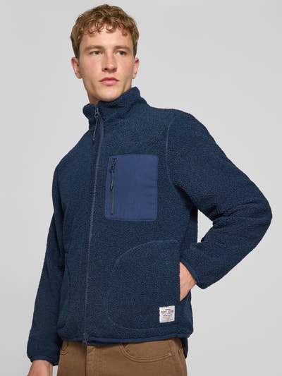 Männermodel trägt Regular Fit Hemdjacke aus Lammfellimitat von Pepe Jeans in Dunkelblau mit aufgesetzter Brusttasche, Nahaufnahme Oberkörper. Herren Hemdjacke von Pepe Jeans.