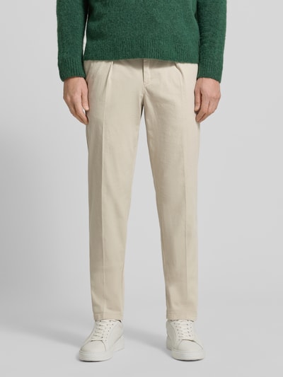 Männermodel trägt Relaxed Fit Hose mit Bügelfalten von Profuomo aus Baumwoll-Elasthan-Mix in Beige, mit Gesäßtaschen, Ganzkörperansicht von vorne.